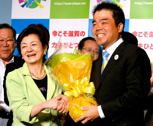 三日月大造氏(右)に花束を渡す嘉田由紀子滋賀県知事=2014年7月13日午後10時40分、大津市、森井英二郎撮影