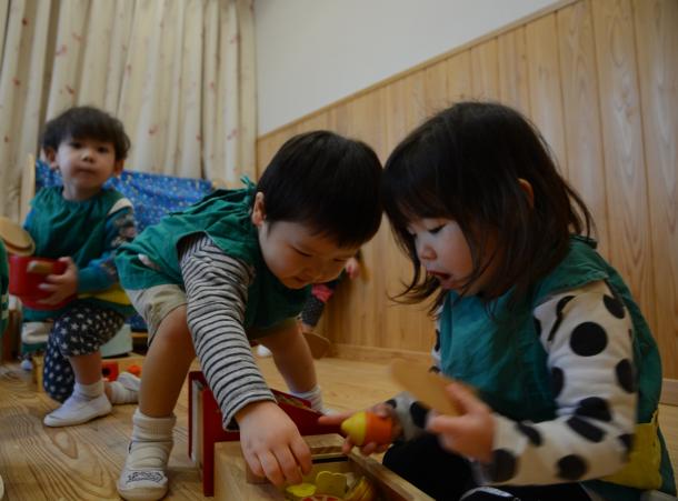 床と腰壁に和泉葛城山系のスギ材を使った乳児室。子どもたちがほのかに木の香りが漂う中で遊ぶ=大阪府高槻市の柱本保育園
