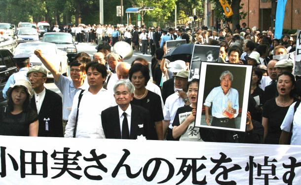 小田実さんの遺影と鶴見俊輔さんを先頭に追悼デモがおこなわれた=2007年8月、東京都港区