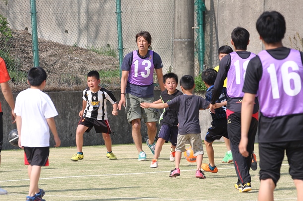 ロアッソ熊本の巻誠一郎(13)らとサッカーを楽しむ避難所の子どもたち=2016年4月19日、熊本県益城町の阿蘇熊本空港ホテルエミナース