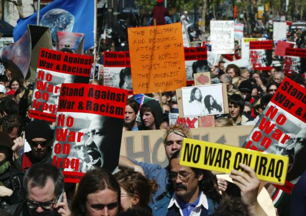 故キング牧師の写真などを掲げ、反戦を訴える人々=2003年3月20日、サンフランシスコ