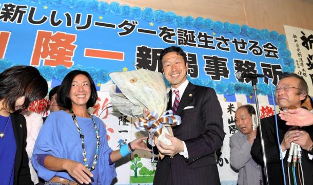 当選を確実にし、支持者から花束を受け取る米山隆一氏