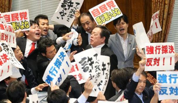 反対する野党銀に囲まれる中、安保関連法案の委員会採決をする浜田靖一委員長(中央右)=2015年7月15日