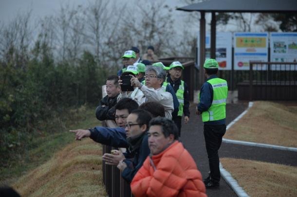 津波警報が出たため、高台に避難した人たち。心配そうに海岸を見つめていた=22日午前6時26分、福島県楢葉町20161122