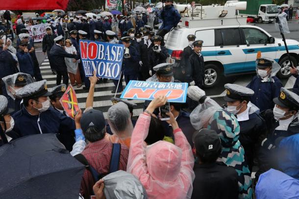 北部訓練場返還式が行われる会場へと向かう交差点で抗議活動をする人たち=22日午後3時50分、沖縄県名護市