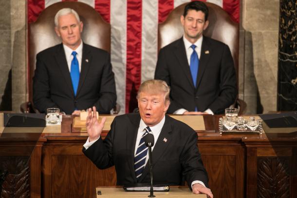米連邦議会で演説をするトランプ大統領。後方にペンス副大統領(左)とライアン下院議長が座り、拍手を送りながら見守った=2月28日、ワシントン、ランハム裕子撮影