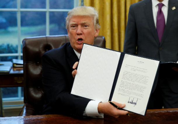 米ホワイトハウスで1月23日、署名した環太平洋経済連携協定(TPP)から離脱するための大統領令を見せるトランプ大統領=ロイター