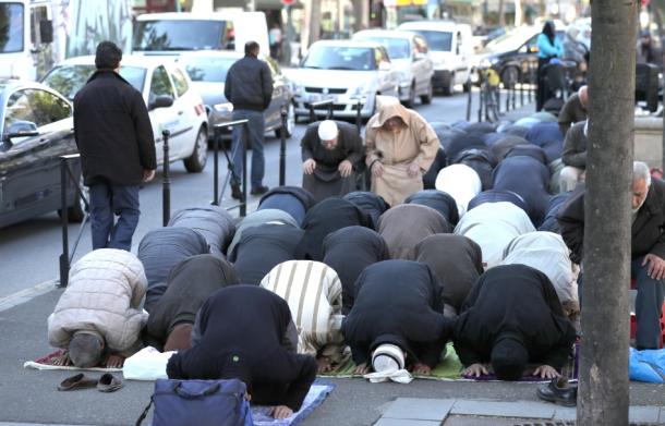 モスクを閉鎖され、抗議の意味も込め、路上で祈りを捧げるイスラム教徒の人たち=19日午後、パリ郊外クリシー市