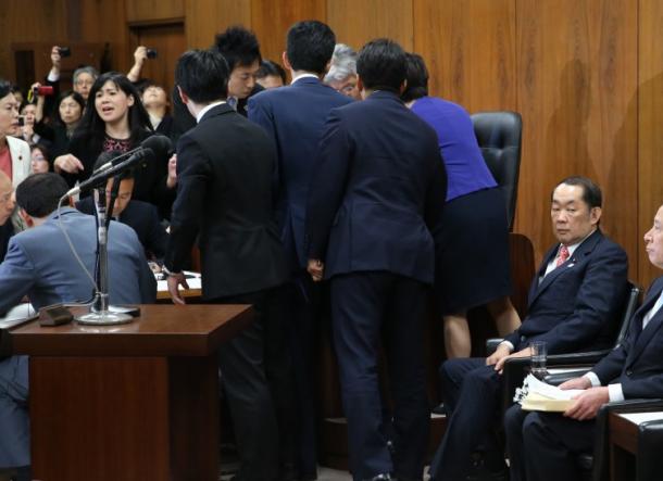 野党委員が委員長席に詰めかける中、組織的犯罪処罰法の改正案の採決を待つ金田勝年法相(右)=19日20170519