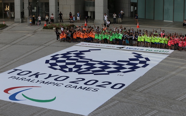 東京五輪のエンブレムからパラリンピックのエンブレムに作り替えるカウントダウンイベント=2016年8月25日、東京都新宿区の東京都庁