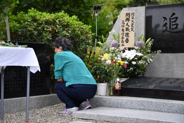 関東大震災での朝鮮人犠牲者を悼み、慰霊碑の前にしゃがみこむ女性=1日午前10時17分、東京都墨田区の都立横網町公園20170901