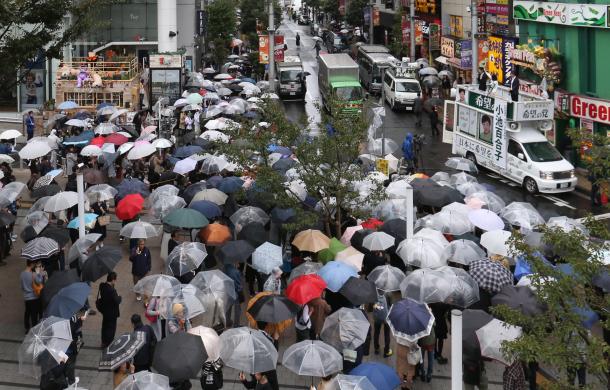 雨の中、街頭演説を聞く有権者たち=10月15日、東京都内(選挙カーなどにモザイクをかけています)