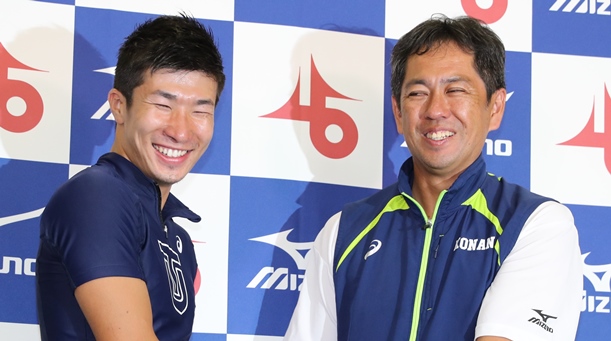 9秒98の日本新記録を出した桐生祥秀選手(左)と笑顔で握手する伊東浩司・日本陸連強化委員長=2017年9月9日、福井市