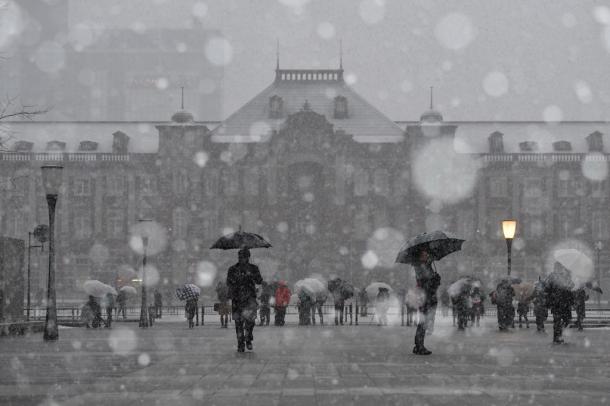 東京駅前の広場でも雪が降り続いた=22日