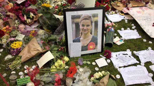 殺害されたコックス議員の写真の周りに、たくさんの人が追悼の花束を置いた=2016年6月、パーラメント広場