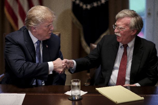 ドナルド・トランプ米大統領(左)と握手するジョン・ボルトン安全保障担当大統領補佐官=2018年4月9日(AP)