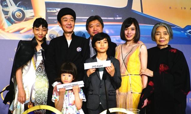 映画「万引き家族」の公式会見の後、撮影のために並んだ(左奥から)安藤サクラさん、リリー・フランキーさん、是枝裕和監督、松岡茉優さん、樹木希林さん、(手前左から)子役の佐々木みゆさん、城桧吏さん=2018年5月14日午前11時1分、カンヌ