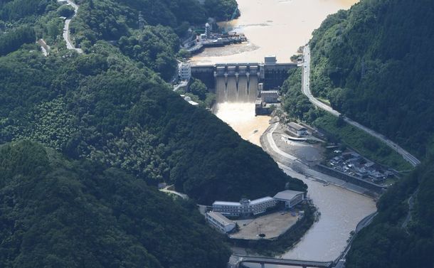 鹿野川ダム(奥)ら肱川へ濁った水が流れていた=2018年7月9日午前9時54分、愛媛県大洲市肱川町、朝日新聞社ヘリから201807月9日